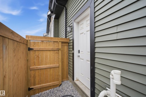 The property features a private fenced entrance leading to a white exterior door - 4047 Hawthorn Link Link, Edmonton, AB - Outdoor With Exterior