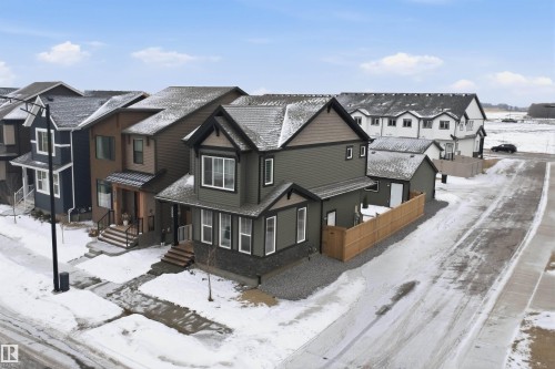 This property features a two-story design with a complementary detached single-story structure, a fenced yard, and a paved driveway - 4047 Hawthorn Link Link, Edmonton, AB - Outdoor With Facade