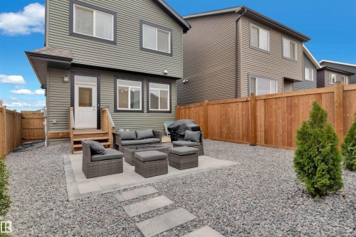 The property features a private backyard with a gravel ground cover and a wooden fence - 4047 Hawthorn Link Link, Edmonton, AB - Outdoor