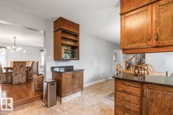 Kitchen area featuring wood cabinetry with dark countertops - 
