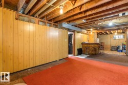 Lower level featuring wood-finish paneling, exposed ceiling joists, and recessed lighting - 