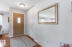 Entryway featuring a panel door with decorative glass insert, wood-finish flooring, and flush mount lighting - 