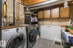 Dedicated laundry area featuring a washer, dryer, built-in cabinetry, and exposed ceiling joists - 
