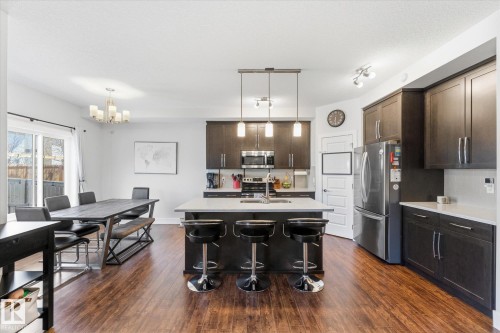 Open-concept kitchen and dining area featuring wood-finish flooring - 54 Cypress Link, Fort Saskatchewan, AB - Indoor Photo Showing Kitchen