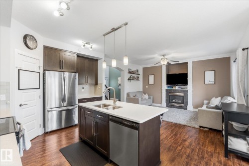 Open-concept main living area with wood-finish flooring - 54 Cypress Link, Fort Saskatchewan, AB - Indoor Photo Showing Kitchen With Double Sink With Upgraded Kitchen