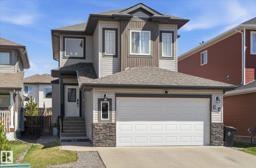 Contemporary two-story home featuring a two-car garage with white panel doors and a paved driveway - 54 Cypress Link, Fort Saskatchewan, AB - Outdoor With Facade