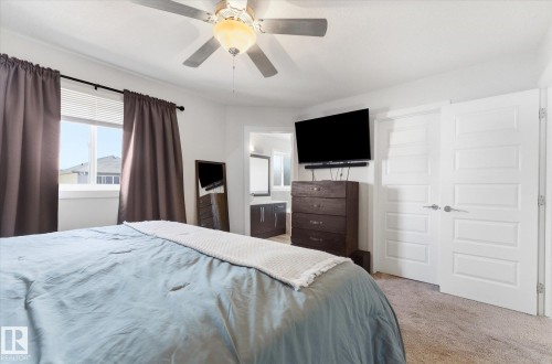 Bedroom with light brown carpet flooring, white walls, and a ceiling fan with integrated lighting - 54 Cypress Link, Fort Saskatchewan, AB - Indoor Photo Showing Bedroom