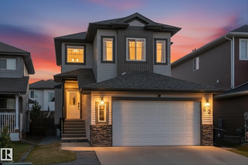 Contemporary two-story residence featuring a two-car garage, stone veneer accents, and a covered front entry - 54 Cypress Link, Fort Saskatchewan, AB - Outdoor With Facade