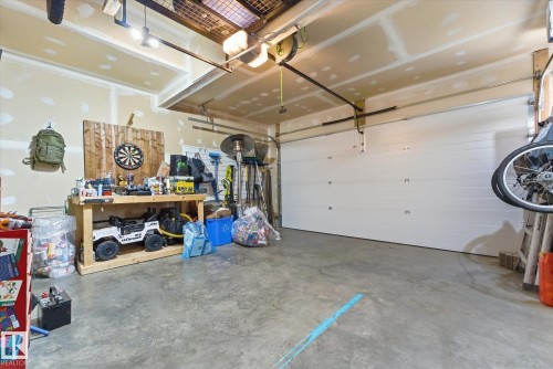 Garage featuring a concrete floor, white panel garage door, and overhead lighting - 54 Cypress Link, Fort Saskatchewan, AB - Indoor Photo Showing Garage