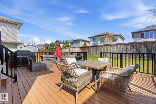 Expansive wood-finish deck featuring black metal railings and a built-in privacy wall - 54 Cypress Link, Fort Saskatchewan, AB - Outdoor With Deck Patio Veranda With Exterior