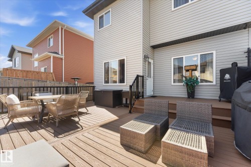 Multi-level composite deck with dark railings, a ground-level patio door, and a vinyl-sided exterior - 54 Cypress Link, Fort Saskatchewan, AB - Outdoor With Deck Patio Veranda With Exterior