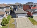 Two-story residence featuring a two-car garage, concrete driveway, and a stone accent facade - 54 Cypress Link, Fort Saskatchewan, AB  - Outdoor With Facade 