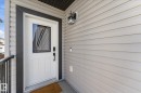 Front entry with a white door featuring a decorative glass insert and black trim - 54 Cypress Link, Fort Saskatchewan, AB  - Outdoor With Exterior 