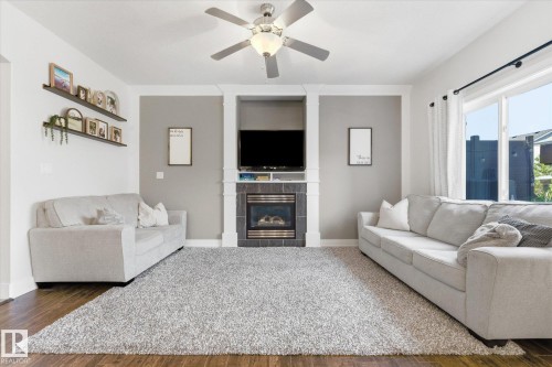 Living area featuring a floor-to-ceiling accent wall with an integrated fireplace and media niche - 54 Cypress Link, Fort Saskatchewan, AB - Indoor Photo Showing Living Room With Fireplace