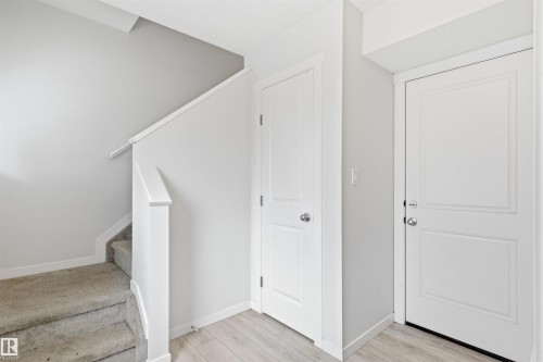 Interior entryway with wood-finish flooring, light grey painted walls, and white trim - 9 850 Secord Boulevard, Edmonton, AB - Indoor Photo Showing Other Room