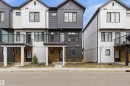 Modern townhome exterior showcasing vertical and horizontal siding in a contrasting black and white palette - 9 850 Secord Boulevard, Edmonton, AB  - Outdoor With Facade 