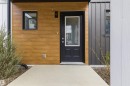 Contemporary exterior featuring wood-finish horizontal siding, dark vertical paneling, and a black front door with an integrated window pane - 9 850 Secord Boulevard, Edmonton, AB  - Outdoor With Exterior 