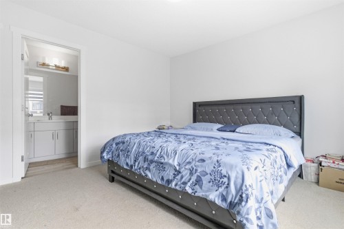 Bedroom featuring soft carpeting and a clear doorway to a bathroom - 9 850 Secord Boulevard, Edmonton, AB - Indoor Photo Showing Bedroom