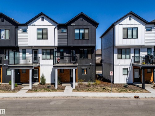 Modern townhome exterior featuring black and white vertical and horizontal siding - 9 850 Secord Boulevard, Edmonton, AB - Outdoor With Facade