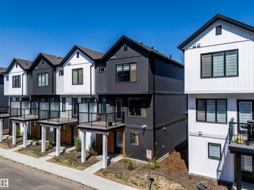 Contemporary townhome architecture featuring alternating black and white vertical and horizontal siding - 9 850 Secord Boulevard, Edmonton, AB - Outdoor With Facade
