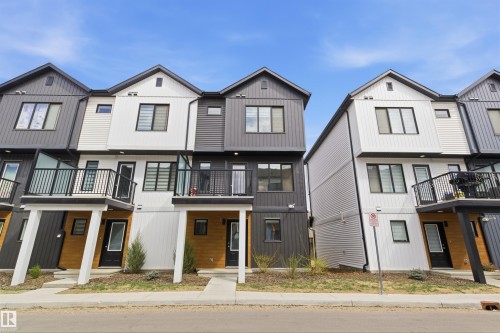 Contemporary townhome featuring a striking white and dark gray facade with horizontal and vertical siding - 9 850 Secord Boulevard, Edmonton, AB - Outdoor With Facade