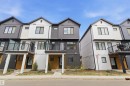 Contemporary townhome featuring a striking white and dark gray facade with horizontal and vertical siding - 9 850 Secord Boulevard, Edmonton, AB  - Outdoor With Facade 