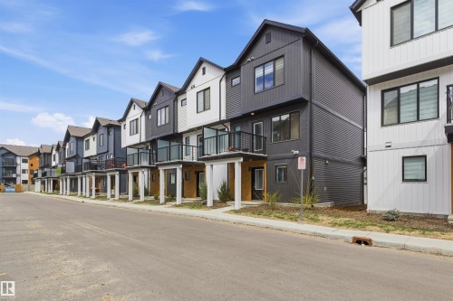 Contemporary townhomes featuring a mix of vertical and horizontal siding, private balconies with glass railings, and a consistent modern architectural aesthetic - 9 850 Secord Boulevard, Edmonton, AB - Outdoor