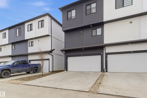 Contemporary multi-level exterior featuring dark and light horizontal siding - 9 850 Secord Boulevard, Edmonton, AB - Outdoor With Exterior