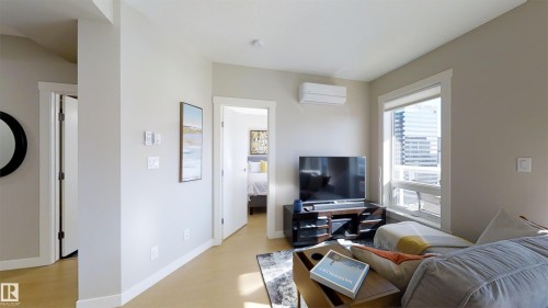 Living area featuring light wood-finish flooring, white baseboards, and neutral wall tones - #1603 10410 102 Av Nw, Edmonton, AB - Indoor Photo Showing Other Room