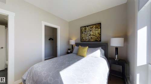 Bedroom with light gray walls, an open closet, and wood-finish flooring - #1603 10410 102 Av Nw, Edmonton, AB - Indoor Photo Showing Bedroom