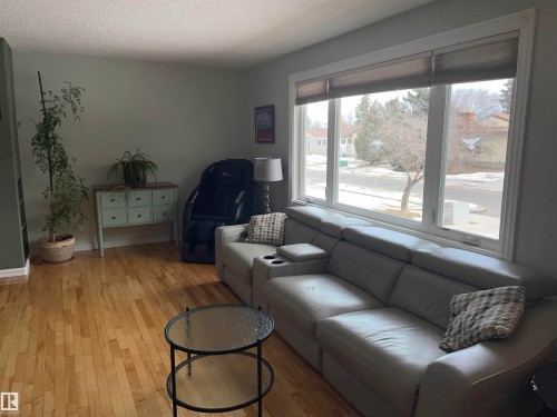 The living area features hardwood floors and a large window offering ample natural light - 14212 30 Street, Edmonton, AB - Indoor Photo Showing Living Room