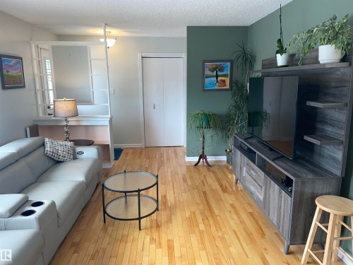 The property features light-toned hardwood flooring throughout this living area - 14212 30 Street, Edmonton, AB - Indoor Photo Showing Living Room