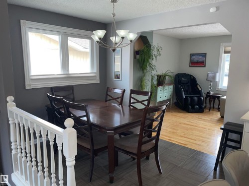 The property features an open living space with a dining area and an additional room, both with windows providing natural light - 14212 30 Street, Edmonton, AB - Indoor Photo Showing Dining Room