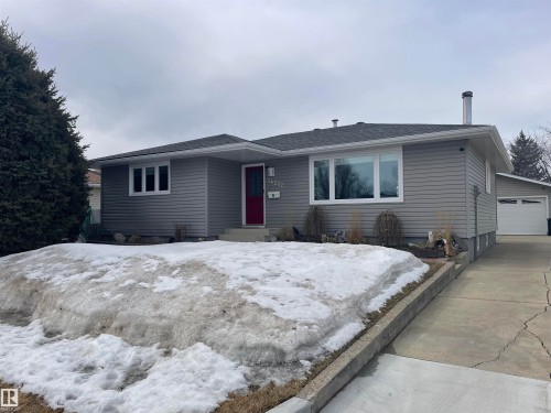 The property features grey siding, white-framed windows, and a red front door - 14212 30 Street, Edmonton, AB - Outdoor