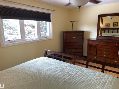 This room features light yellow walls and a ceiling fan with a light fixture - 14212 30 Street, Edmonton, AB - Indoor Photo Showing Bedroom