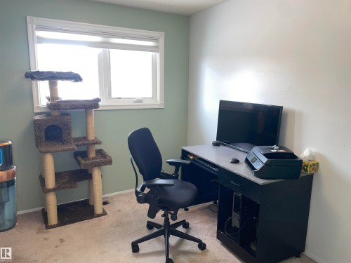 This room features a window providing natural light, carpeted flooring, and walls painted in a two-tone color scheme - 14212 30 Street, Edmonton, AB - Indoor Photo Showing Office