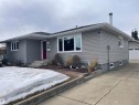 The property features grey siding, white-framed windows, and a red front door - 14212 30 Street, Edmonton, AB  - Outdoor 
