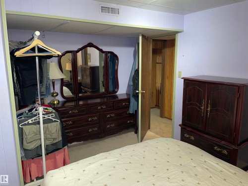 The room features light purple paneled walls and a white textured ceiling - 14212 30 Street, Edmonton, AB - Indoor Photo Showing Bedroom