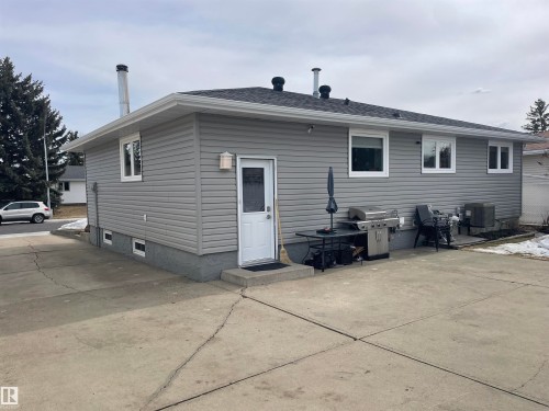 The property features gray siding, a white exterior door, and multiple windows - 14212 30 Street, Edmonton, AB - Outdoor With Exterior