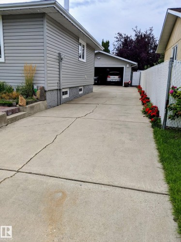The property features a concrete driveway leading to a detached garage - 14212 30 Street, Edmonton, AB - Outdoor With Exterior