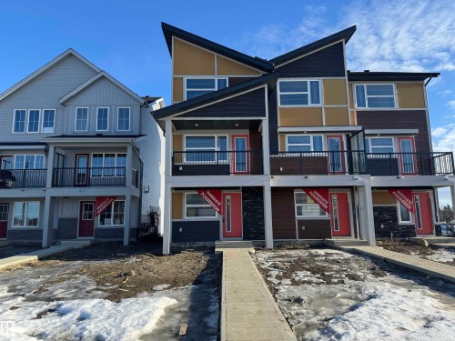 View of front facade featuring board and batten siding, brick siding, a shingled roof, and a balcony - 17235 4 Street, Edmonton, AB - Outdoor With Balcony With Facade