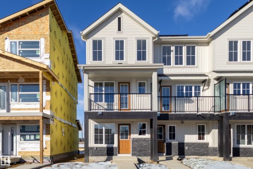 View of front facade featuring board and batten siding, brick siding, a shingled roof, and a balcony - 17232 4 Street, Edmonton, AB - Outdoor With Balcony With Facade