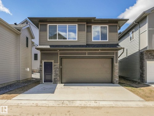 Contemporary two-story exterior featuring a grey and tan facade with stone accents - 6125 Crawford Drive, Edmonton, AB - Outdoor