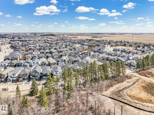 Aerial perspective showcasing a residential development with multiple single-family homes featuring varied architectural styles and dark-toned roofing - 6125 Crawford Drive, Edmonton, AB - Outdoor With View