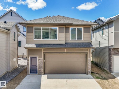 Contemporary two-story residence featuring a two-car garage, partial stone facade, and a dark asphalt shingle roof - 6125 Crawford Drive, Edmonton, AB - Outdoor