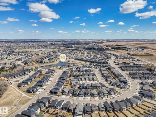 Aerial perspective showcasing a residential community with a central pond feature - 6125 Crawford Drive, Edmonton, AB - Outdoor With View