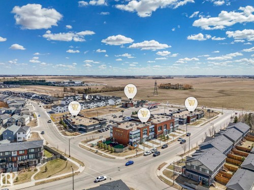 Aerial perspective showcasing a residential development with various housing styles and commercial buildings - 6125 Crawford Drive, Edmonton, AB - Outdoor With View