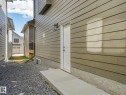 Exterior featuring horizontal siding, a white entry door, and an exterior wall lantern - 6125 Crawford Drive, Edmonton, AB  - Outdoor With Exterior 