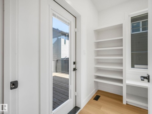Glass-paneled door leading to an exterior deck with wood-finish flooring - 6125 Crawford Drive, Edmonton, AB - Indoor