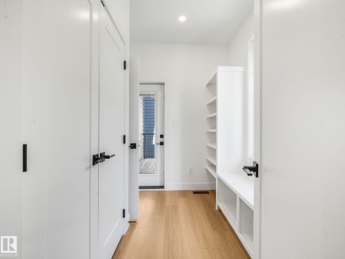 Hallway featuring wood-finish flooring, recessed lighting, and a built-in storage unit with shelving - 6125 Crawford Drive, Edmonton, AB - Indoor Photo Showing Other Room